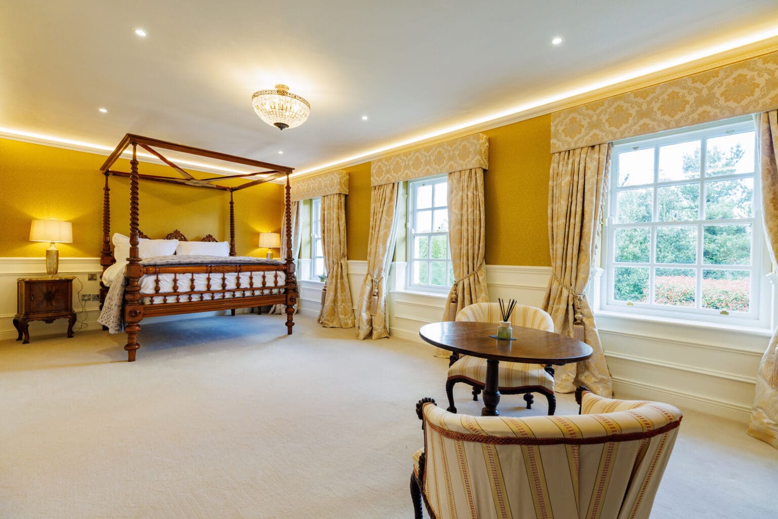 Four-poster bed in a spacious Rochtaine Mount Juliet bedroom overlooking the gardens