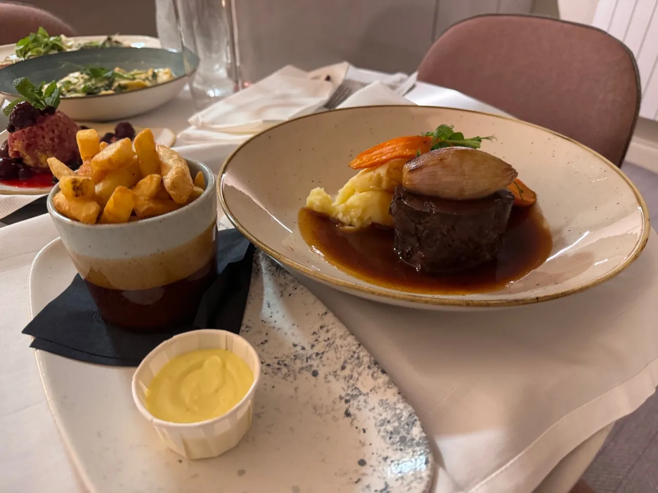 Plated main course with vegetables, sauce and a side of chips